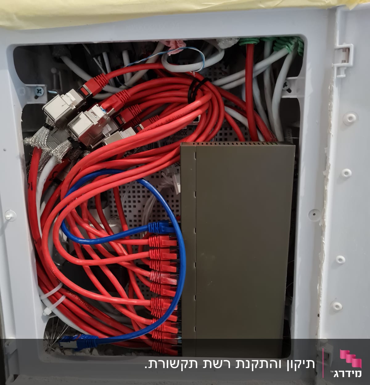 ארון תקשורת עם כבלים אדומים וכחולים מחוברים